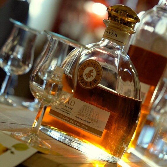 En flaska cognac med etikett och ett glas. 1