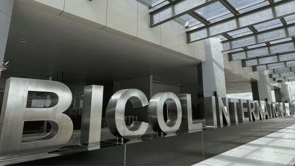 A modern building with large metallic letters spelling 'BICOLINTERNATIONAL' on the facade. 1