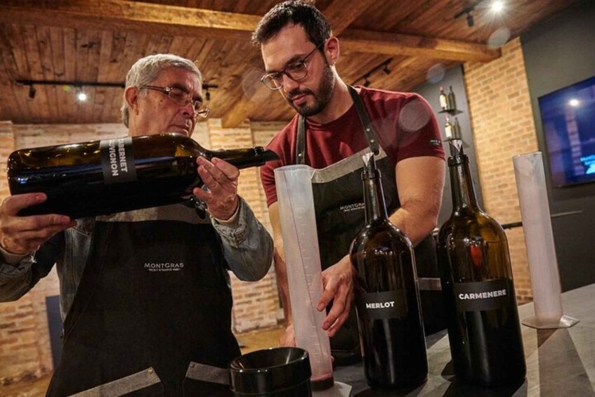 Two people tasting wine at a bar with wooden ceilings and brick walls. 1