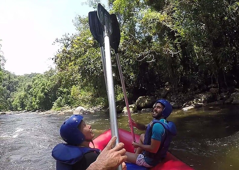 Two people in a raft on a river surrounded by greenery. 4