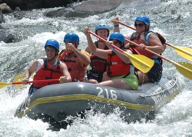 A group of people in a raft navigating a river. 5