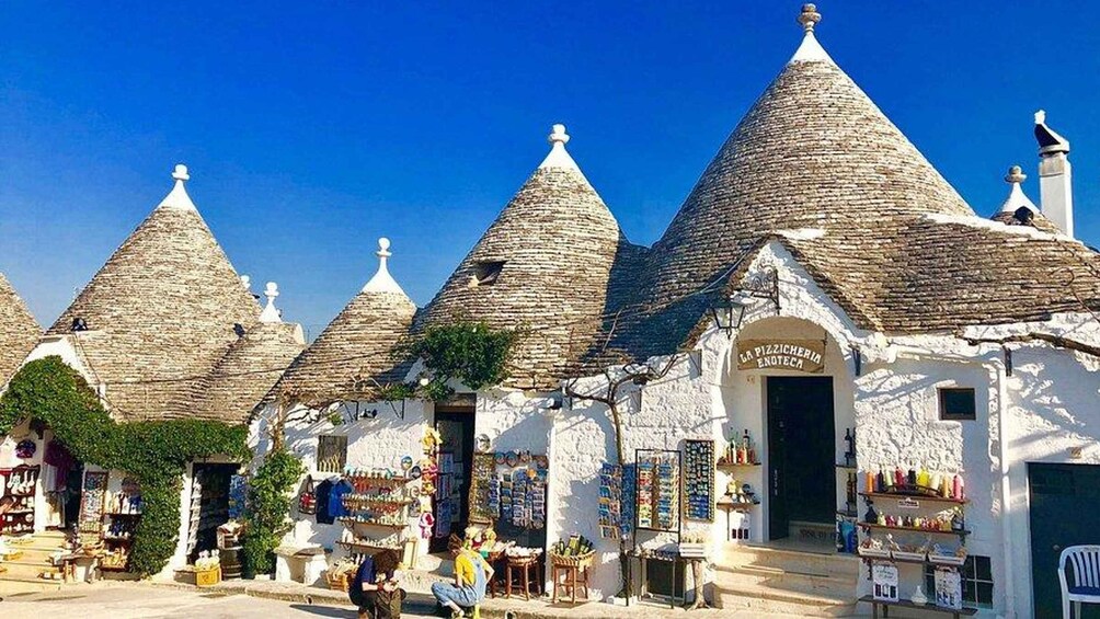 Traditional stone-roofed buildings with shops and a clear blue sky. 2