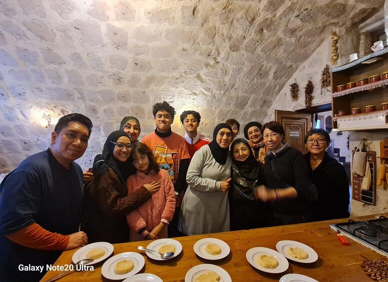 A group of people in a rustic, stone-walled room with a wooden table in the foreground. 5