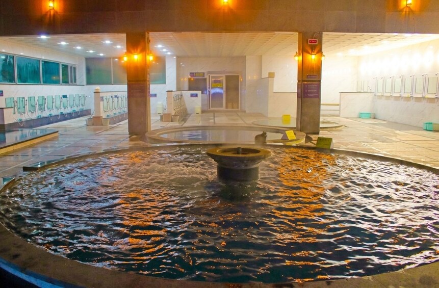 Ein öffentlicher Innenraum mit einer zentralen Wasserspiele, Bänken und Handwaschbecken. 4