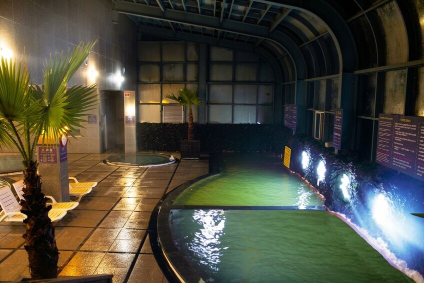 Ein Hallenbad mit Wasserspielen, Sitzbereichen und Informationstafeln. 3