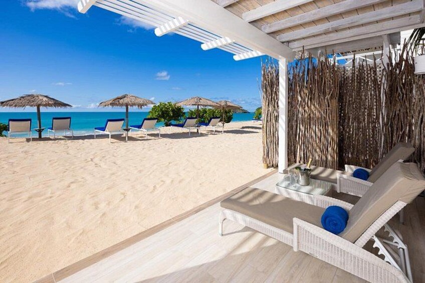 A beach with lounge chairs, a wooden deck, and a view of the ocean. 3