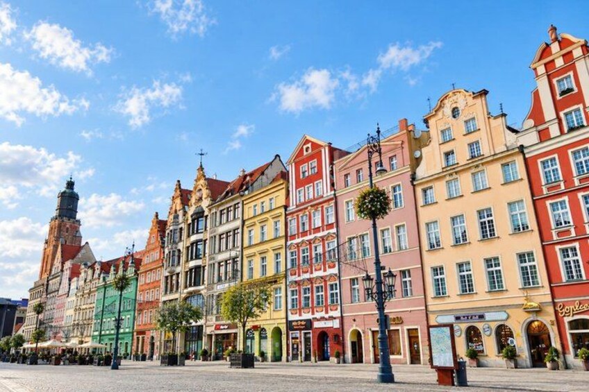 A row of colorful historic buildings with a church steeple in the background. 5