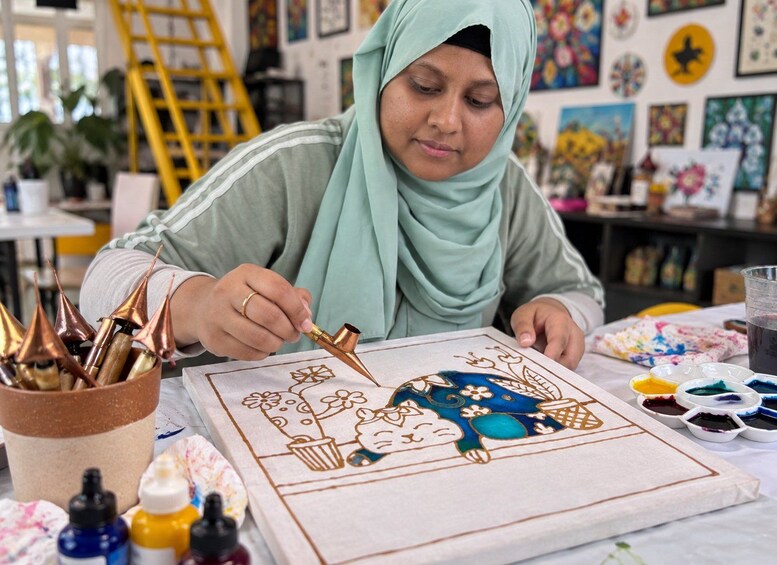 A person working on a detailed drawing with various art supplies on a table. 2
