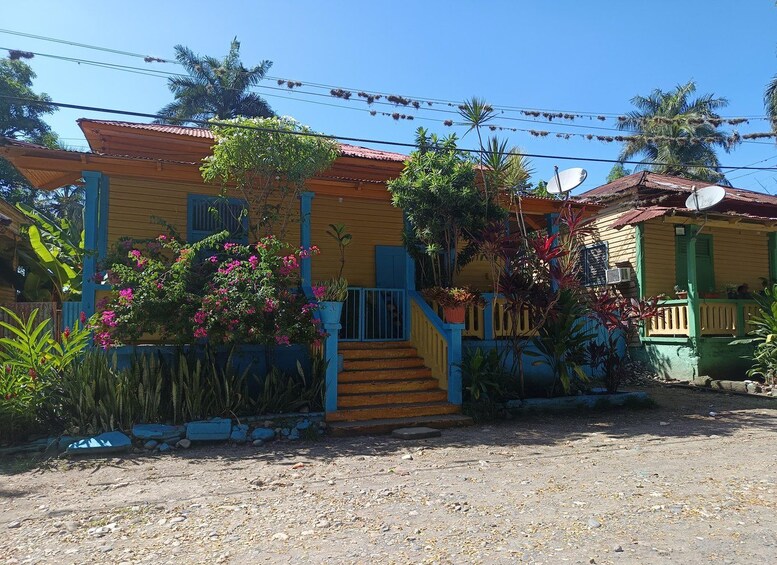 A colorful house with a red roof, blue and yellow walls, and a small porch. 4