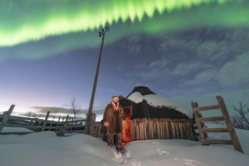 A person in a snowy landscape with a wooden structure and a mountain in the background. 2