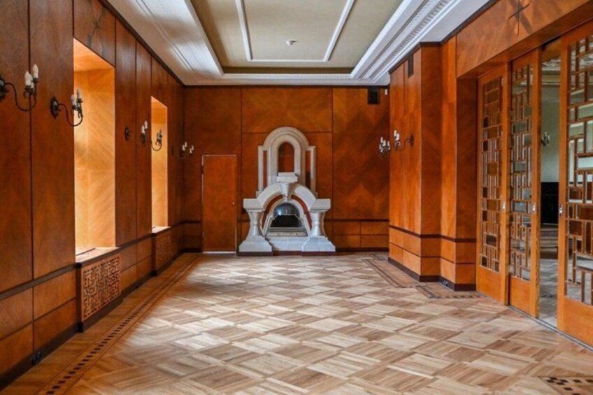 A hallway with wooden paneling, a tiled floor, and a fireplace. 4