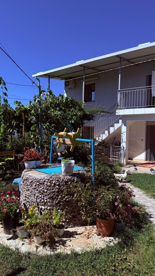A residential building with a balcony, a stone wall, and potted plants. 4