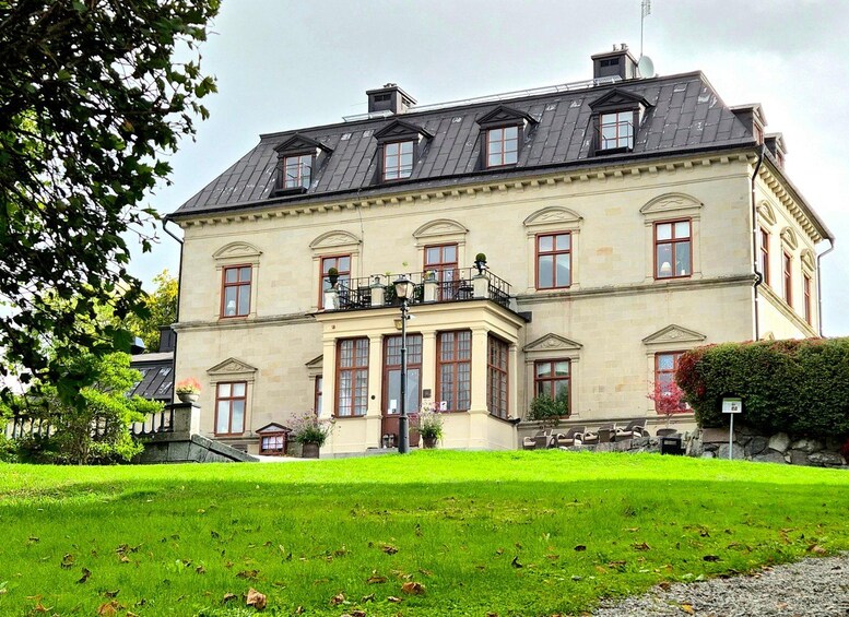 A large, historic building with a symmetrical facade, multiple windows, and a prominent balcony. 2