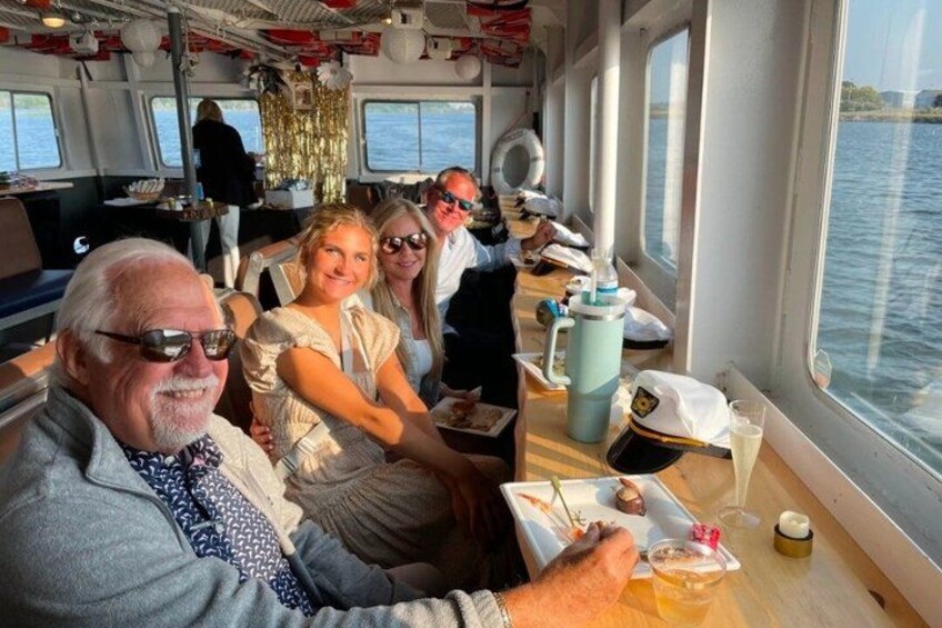 A group of people on a boat with a table in the foreground. 2