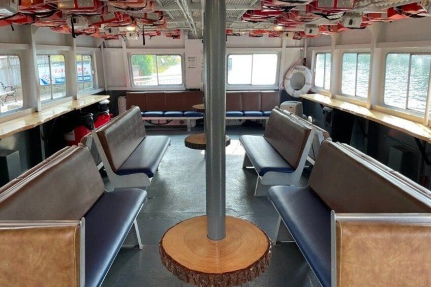 A boat interior with seating, windows, and a central wooden column. 3