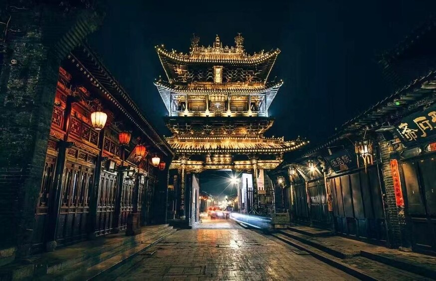 A traditional multi-tiered pagoda at night, illuminated by street lamps and lights. 3