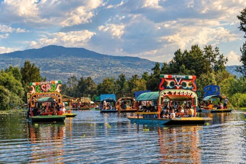 Colorful boats on a river with a mountainous backdrop. 1