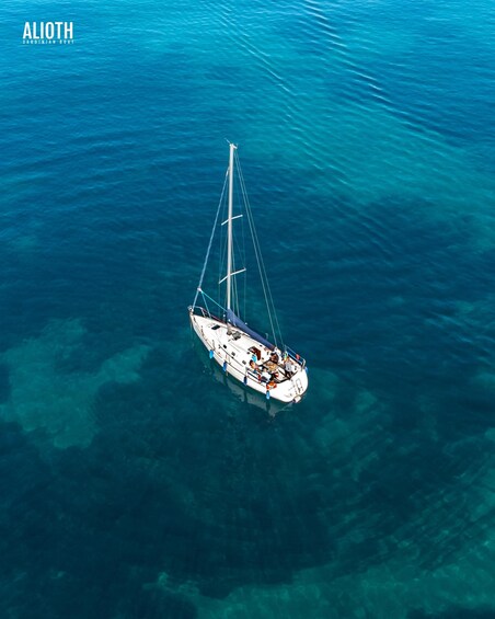 A sailboat on clear turquoise water. 1