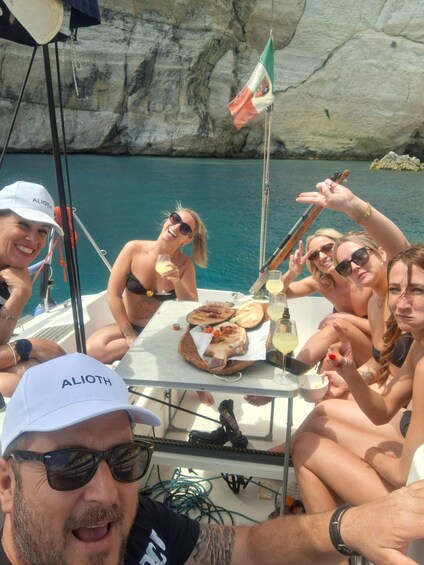 A group of people on a boat with a rocky coastline in the background. 3