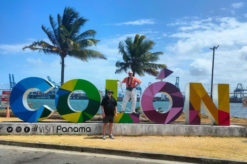 A colorful sign with the word 'COLON' and palm trees in the background. 1
