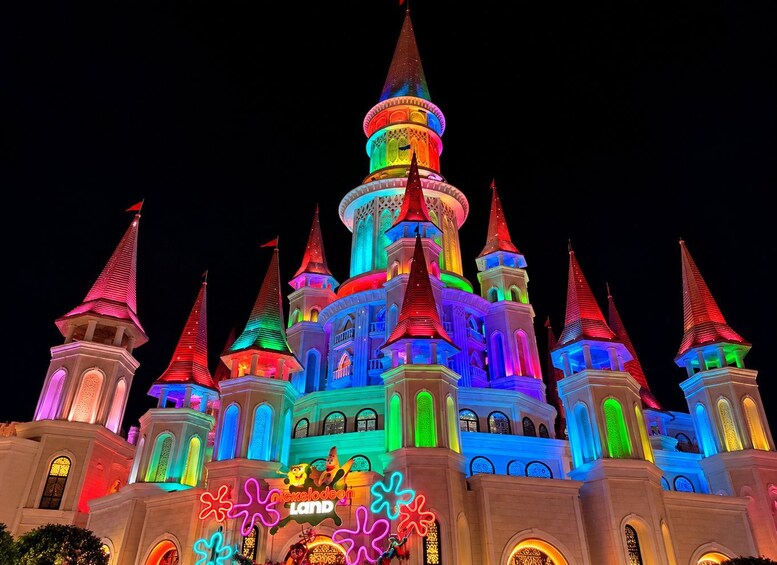 A brightly lit castle with multiple spires and colorful lights. 1
