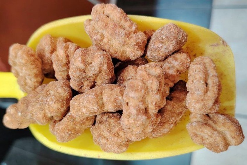 A yellow plastic scoop filled with round, brown, crispy snacks. 4