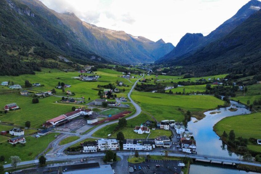 A valley with a river, houses, and a road. 1