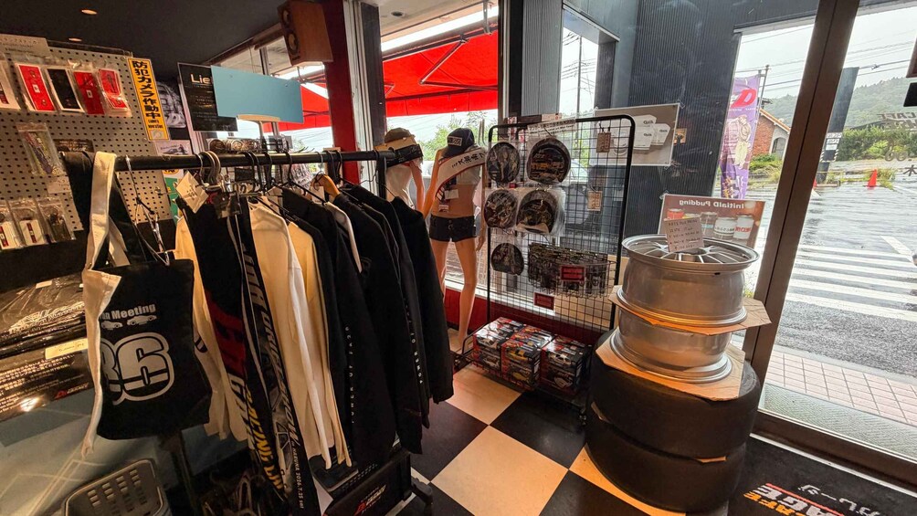 A clothing store with racks of clothes, a display of hats, and a large metal sculpture. 3