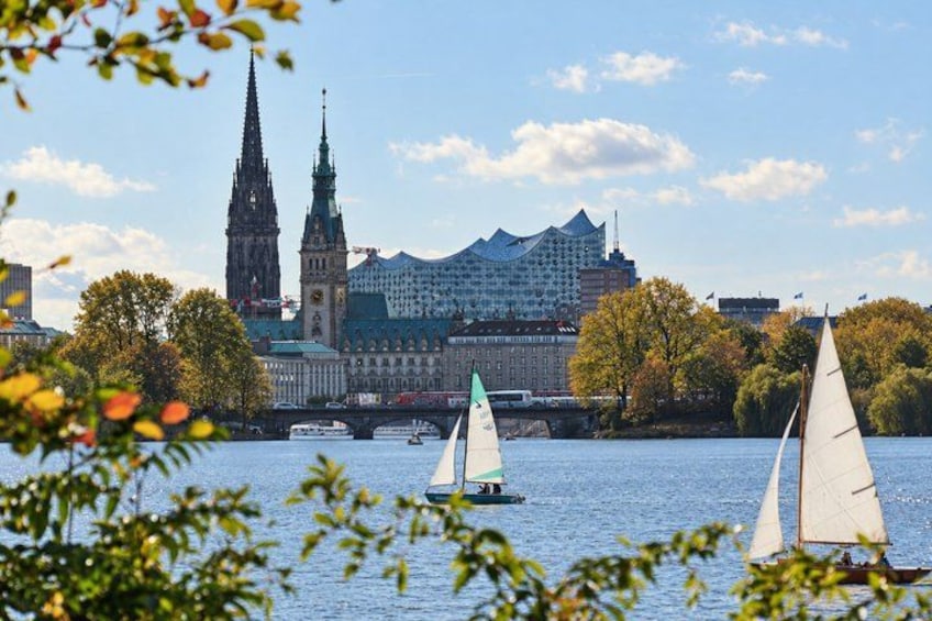 A river with sailboats, a bridge, and a historic building with spires. 4
