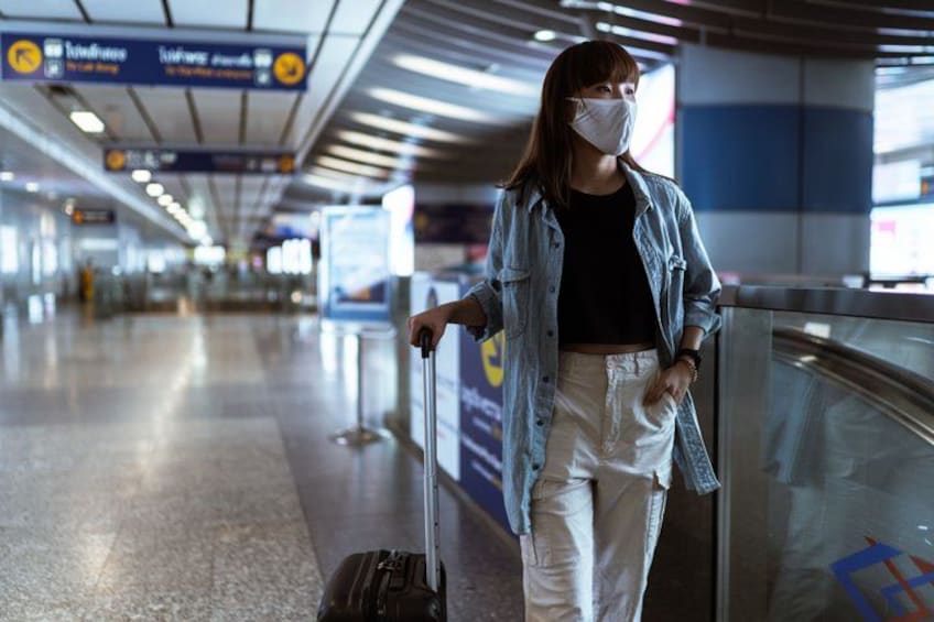 A person with a suitcase in an airport terminal. 2