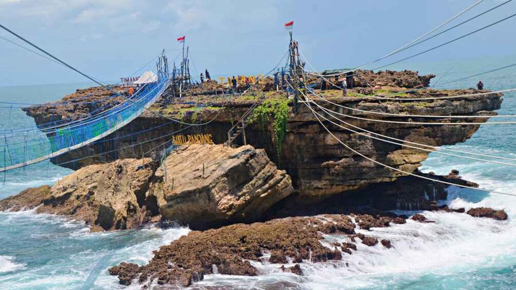 A shipwreck on a rocky outcrop surrounded by the ocean. 2