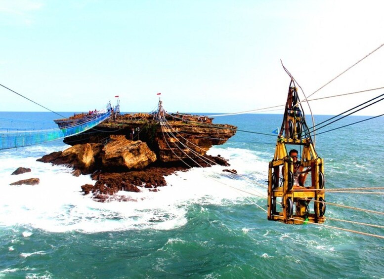 A rocky island with a fishing boat and a small yellow structure in the water. 1