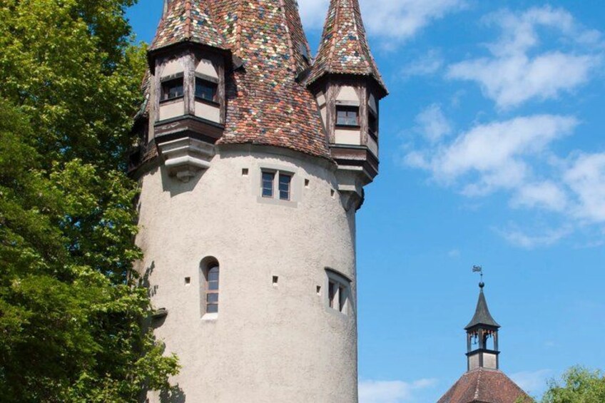 A castle tower with a conical roof and a smaller tower with a weather vane. 5