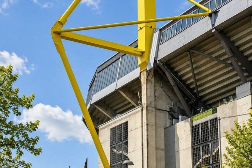 A modern building with large windows and a yellow structural element. 2