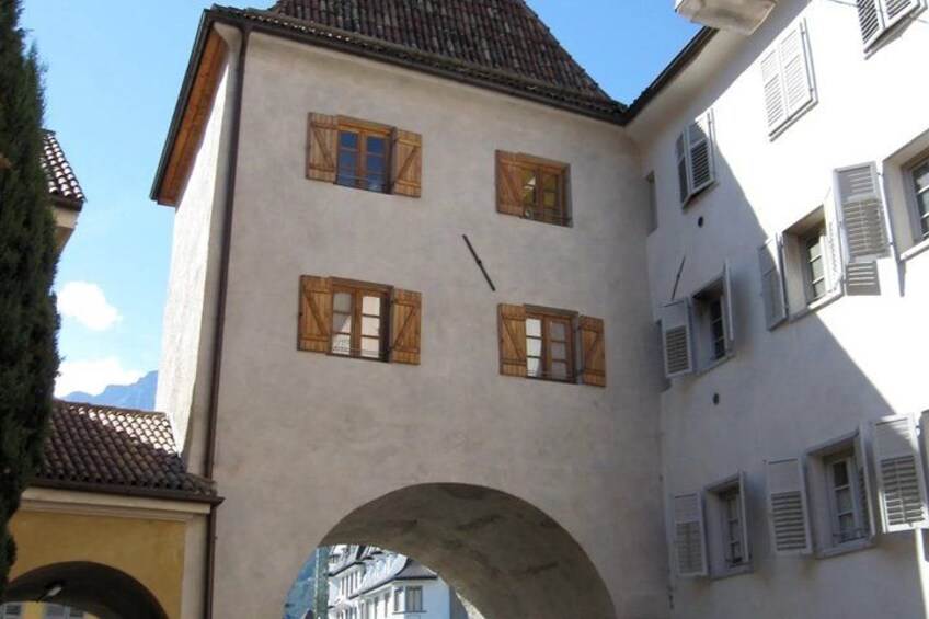 A building with a white facade, wooden shutters, and a tiled roof. 2