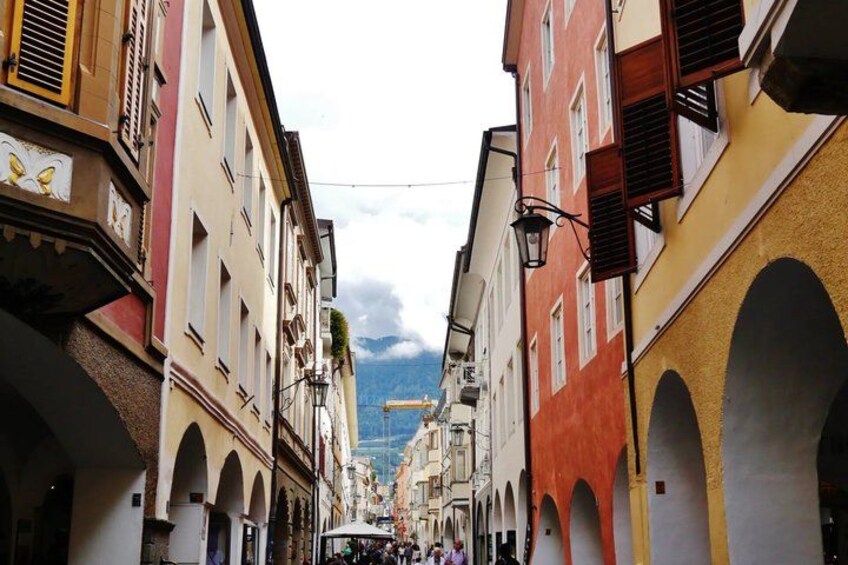 A narrow street flanked by colorful buildings with arched windows and balconies. 4