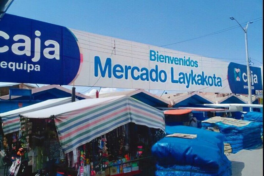 A market with tents and a large sign welcoming visitors to Mercado Layakota. 4