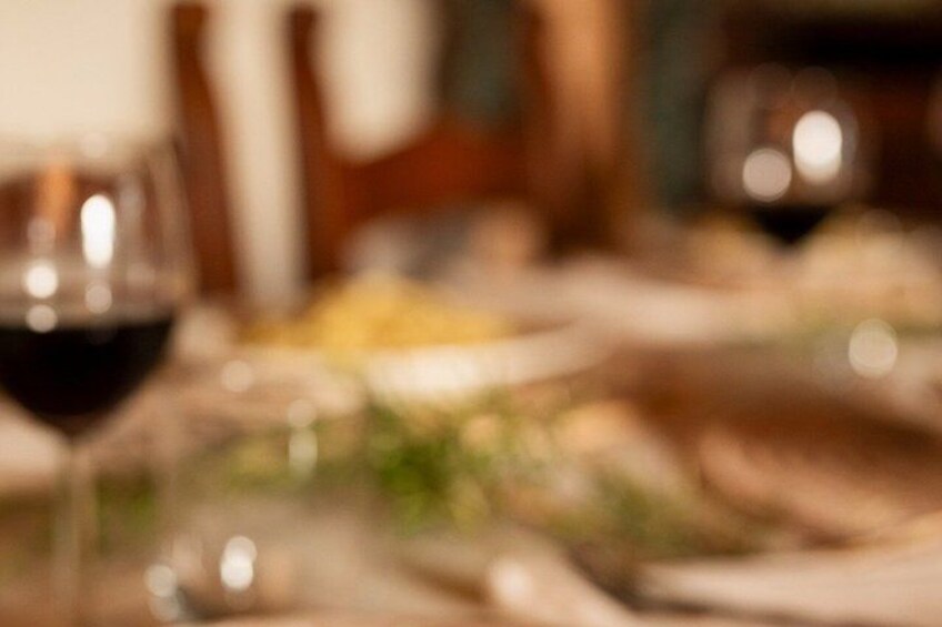 A blurred dining table with a glass of red wine. 1