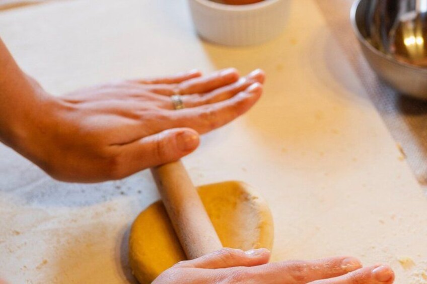 Hands rolling dough on a countertop. 4