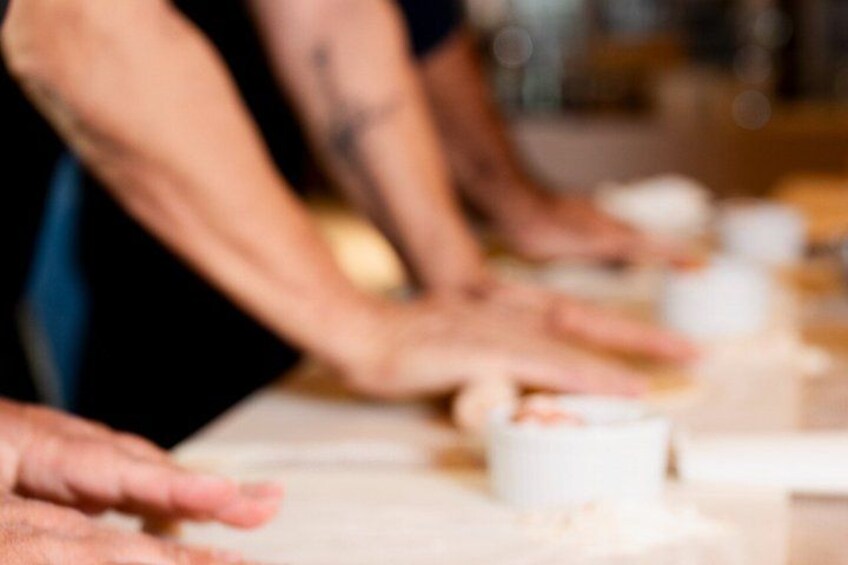 Hands reaching for bowls of food, suggesting a communal eating setting. 3