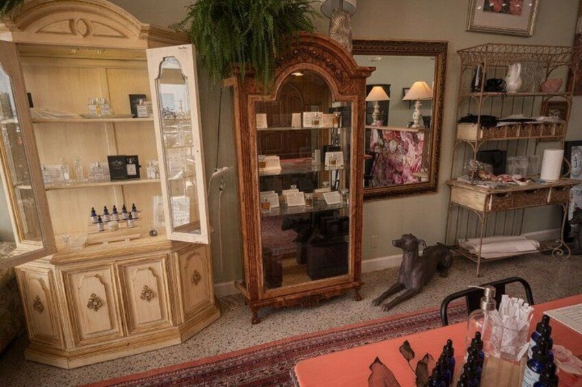A room with antique furniture, including a wooden cabinet, a mirror, and a dog statue. 2
