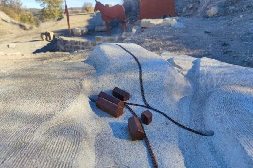 A sandy surface with a rope and three wooden blocks. 5