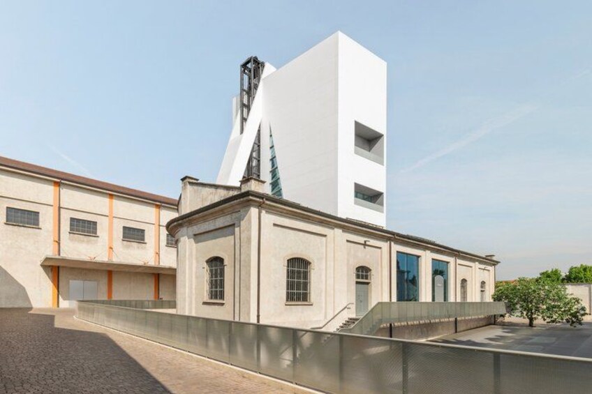A modern building with a white facade and a unique tower structure. 3