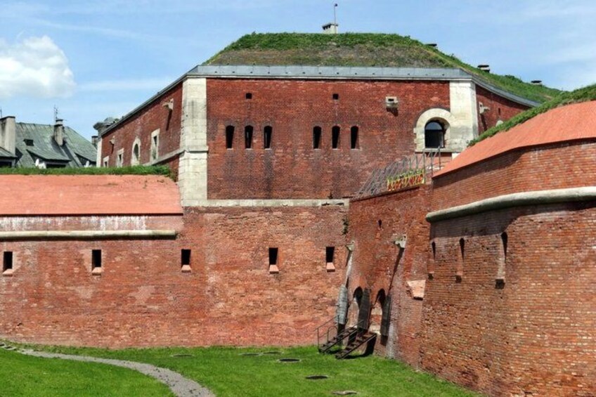 A brick fortress with a grassy courtyard and a small hill with a flag. 5