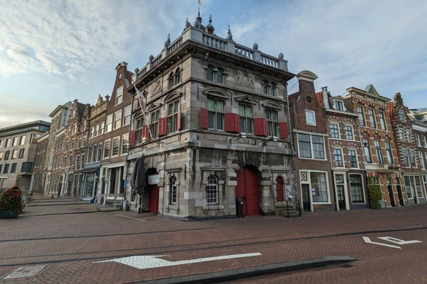 A historic building with red shutters, a cobblestone street, and a tram track. 5
