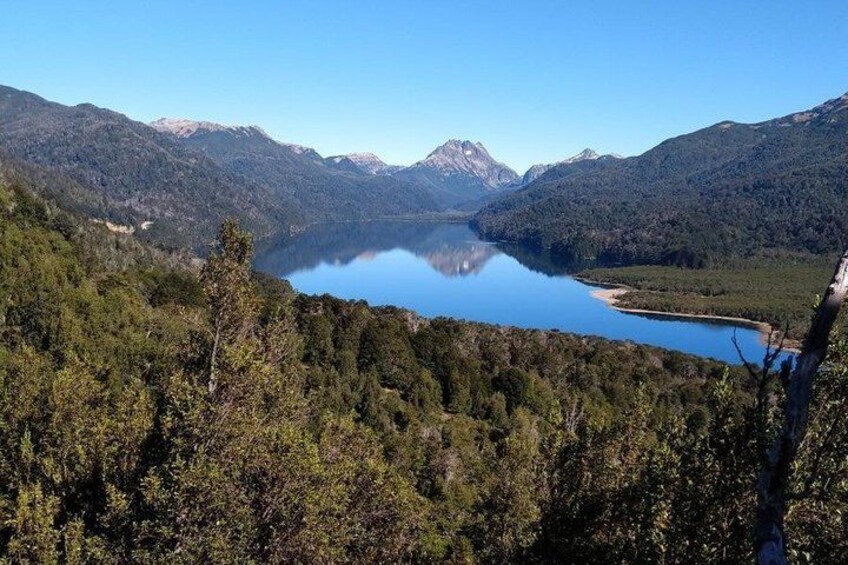A mountainous landscape with a lake and forested area. 4