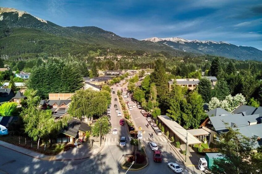 A town with a main road, buildings, and mountains in the background. 1