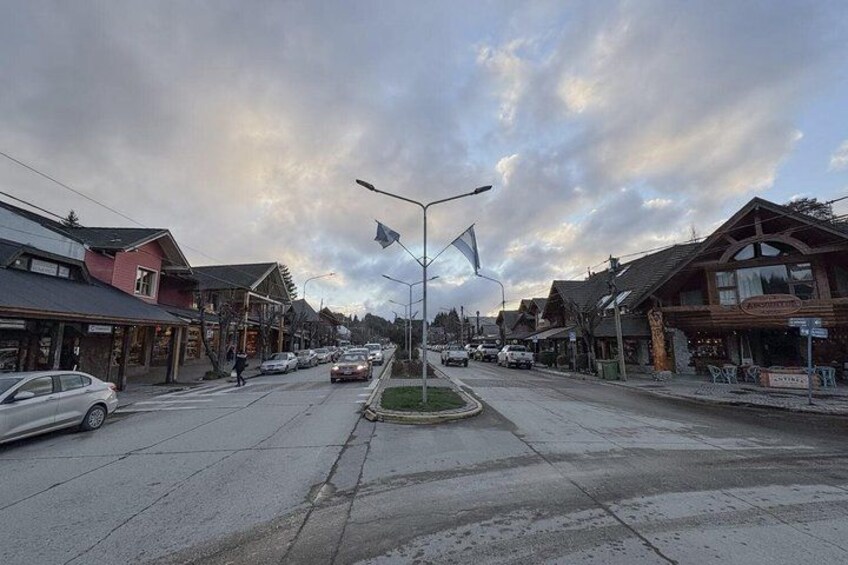 A street with buildings, cars, and a pedestrian crossing. 2