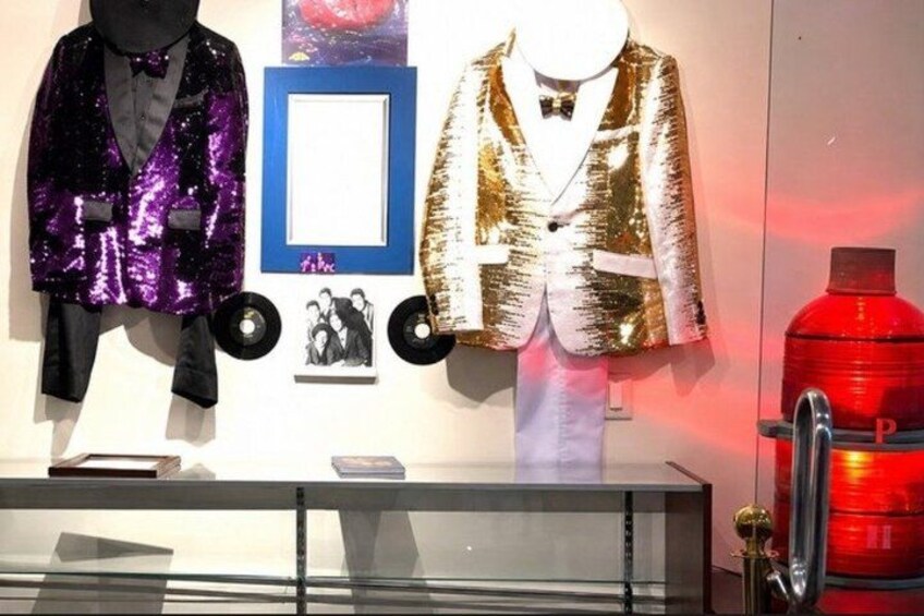 A display of sequined jackets, a framed picture, and a fire extinguisher. 2