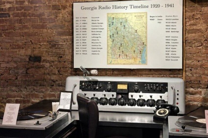 A vintage radio with a timeline and map on the wall behind it. 5
